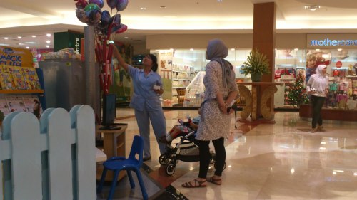 h mum with baby buying toys
