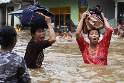 jakarta flood 2013 woman with bag on head, jakarta flood, worst flood in Indonesia